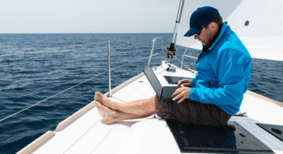mezczyzna na jachcie z laptopem